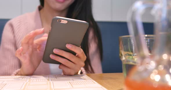 Woman using smart phone in restaurant