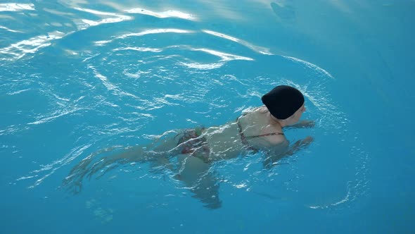 Woman Is Swimming Freestyle in Pool with Breath-holding.