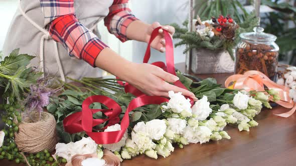 Young Female Florist with Red Ribbon for Flowers