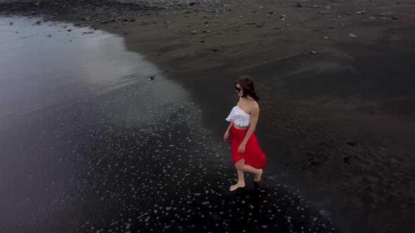 Young Woman Enjoying Vacation on Black Sand Beach