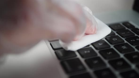 Man Cleaning Laptop Keyboard With Antibacterial Disinfecting Wipe for Killing Coronavirus.