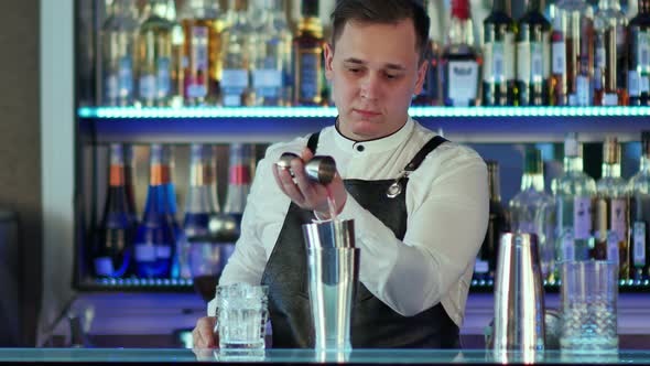 Bartender Makes a Cocktail at the Bar, Pours To a Glass From Shaker