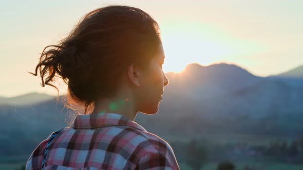 Woman Traveler Enjoying a Sunset in a Mountainous Landscape