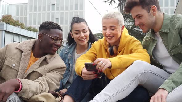 Group of Multiethnic Students Sitting in a Campus Looking at Mobile Phone