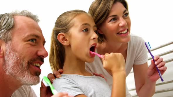 Family brushing teeth in bathroom