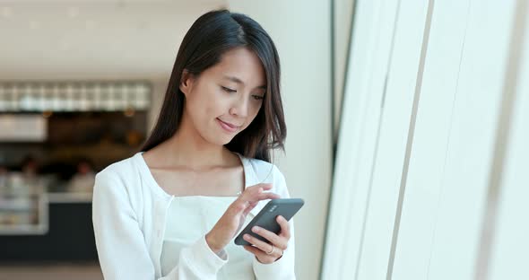 Woman using cellphone inside shopping center