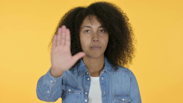 African Woman Stop Sign By Hand, Yellow Background 