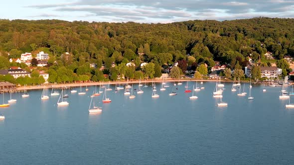 Boats tied up at lake. Sailboats anchor in harbor. Aerial view flying drone of town Herrsching at Am