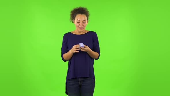 Curly Woman Opening Small Box with a Surprise and Very Rejoicing . Green Screen