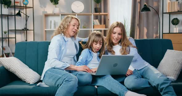 Female Persons which Resting on Soft Couch at Home and Revisioning Interesting Program on Laptop