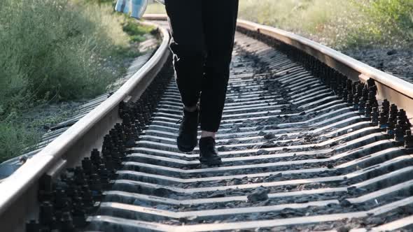 Young Beautiful Woman Walks Alone on the Railway Track