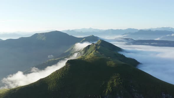 Drone Shot of the Schwalbenwand Mountains Engulfed in Mist on a Sunny Day