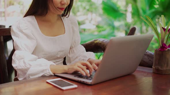 Young woman freelancer traveler working online using laptop while traveling on vacation