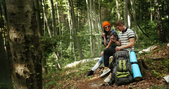 Couple of Tourists Relaxing in Forest