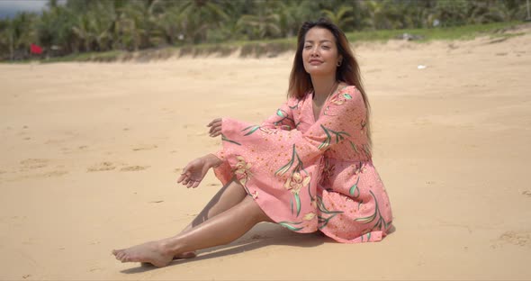 Barefoot Ethnic Woman Sitting on Beach