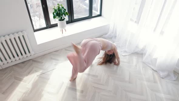 Modern Dancing  Young Acrobatic Woman Dances in White Spacious Room By the Windows