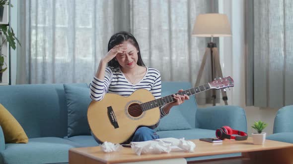 Asian Woman Composer With A Guitar Crumpled Paper And Throw It Away While Composing Music At Home