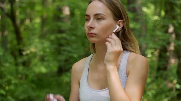 Young Girl Is Put on Earphones and Runing in Park in Summer, Healthy Lifestyle.