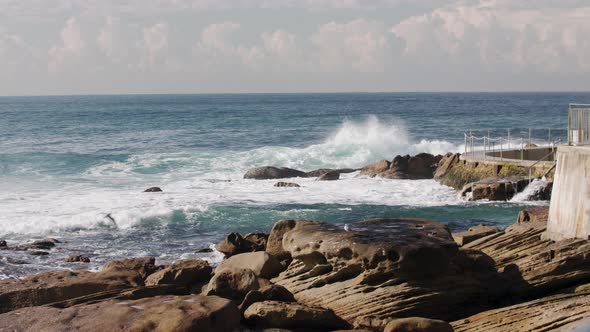 Waves crash along the seawall near the Bondi Beach ocean lap pool in Australia