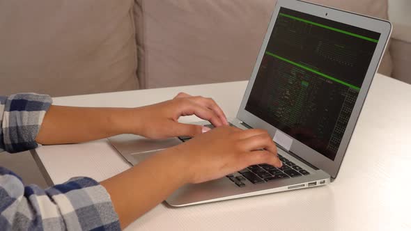 A Woman Quickly Types Text on a Laptop Keyboard While Sitting at Home