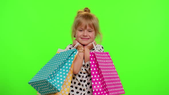 Kid Girl Showing Shopping Bags Advertising Discounts Low Prices Shopping on Black Friday Holidays