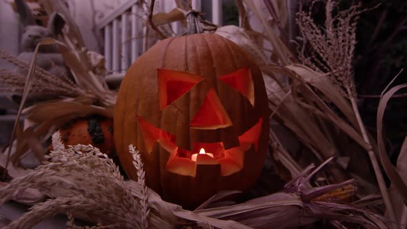 Jack o'lantern with candle flickering rotating around it on porch