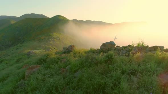 Aerials of California poppy fields and mountains and early sunrise with fog rolling in.