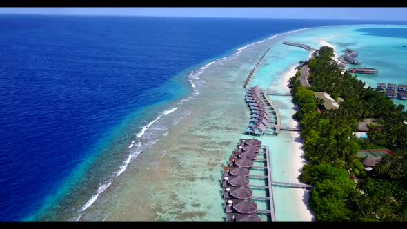 Aerial abstract of idyllic tourist beach vacation by blue water and white sand background of a picni