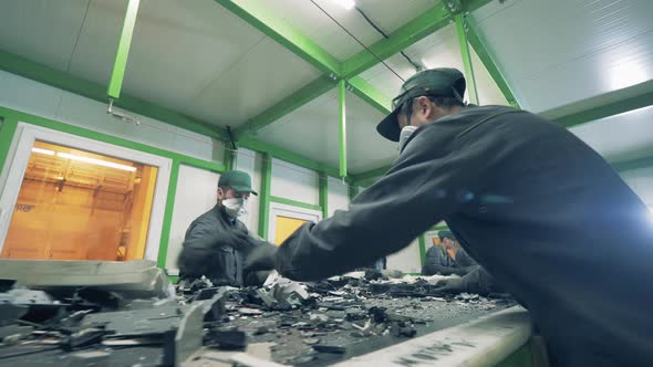 Junkyard Workers Are Sorting Fragments of Waste on a Conveyor