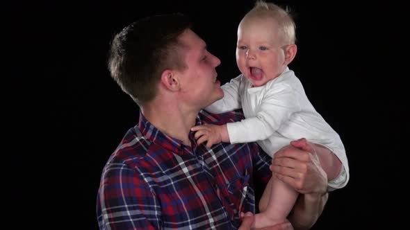 Mother Tenderly Kissing Her Cute Newborn Baby Son. Black