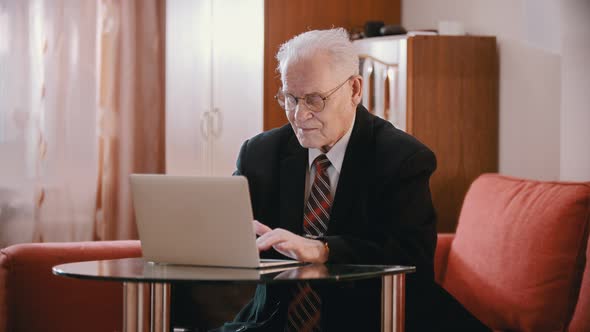 Elderly Grandfather - Old Grandfather with Glasses Is Typing on a Computer