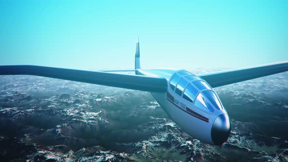 The white sailplane calmly gliding in the sky over the snow-covered mountains.