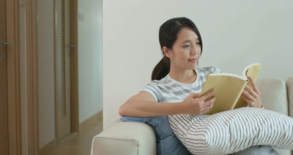 Woman Read on Book and Sit on Sofa at Home