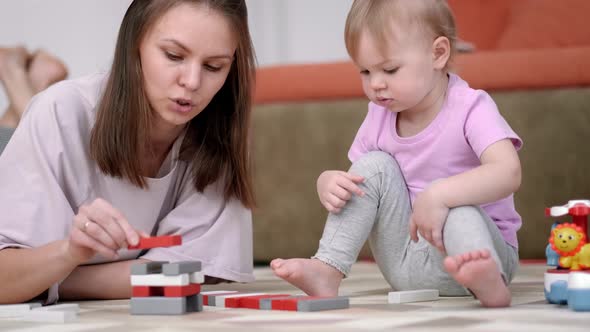 Little Baby Girl and Mommy Playing Color Wooden Toys at Home Sitting on Floor Mother and Daughter