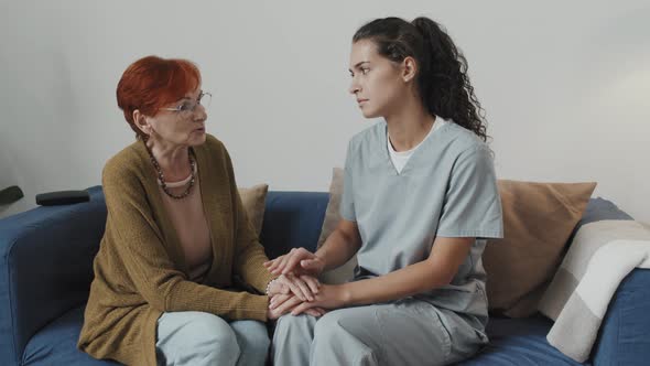 Nurse Supporting Senior Woman in Nursing Home