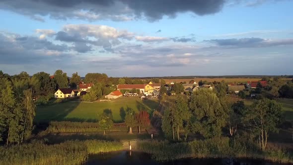 Gorgeous aerial drone flight slowly rise up drone shot of a lonely blond girl in pink dress at summe