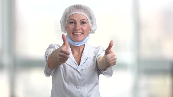 Cheerful Woman Surgeon Giving Two Thumbs Up.