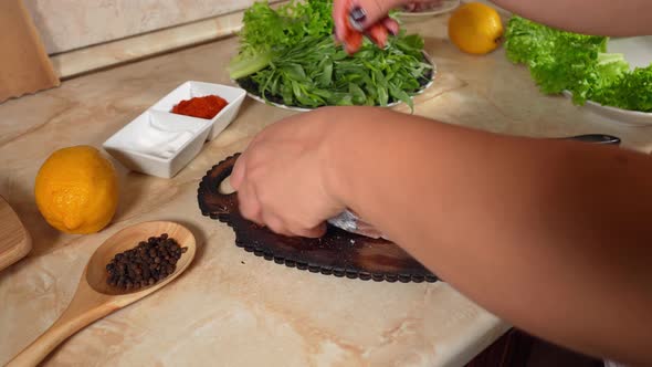 Womans Hand  Pours Ground Red Pepper  On Two Pieces Salmon Fish