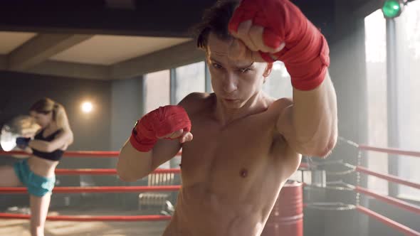 Male Boxer Hitting in the Air on the Camera in the gym