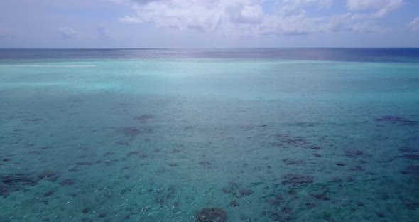 Wide drone copy space shot of a white paradise beach and blue water background in vibrant 4K