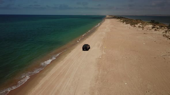 SUV Rides on the Water with Splashes on the Black Sea Beach