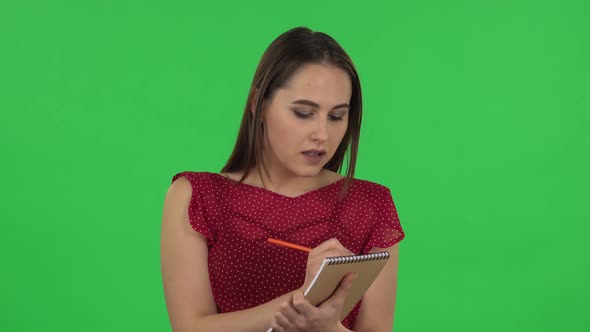 Portrait of Tender Girl in Red Dress Is Standing and Thinking, Then Happy Writing with Pencil in