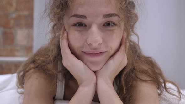 Smiling Young Female Face Lying in Bed