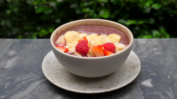 Healthy Acai Smoothie Bowl on Marble Table in Luxury Outdoor Restaurant or Cafe