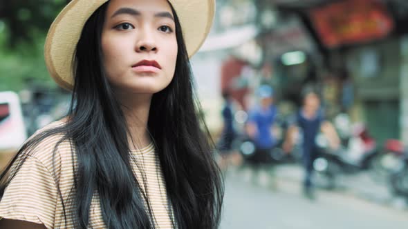 Handheld view of Vietnamese woman with mobile phone waiting for taxi