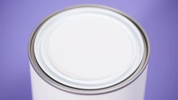 Opening metal paint can with violet interior paint.