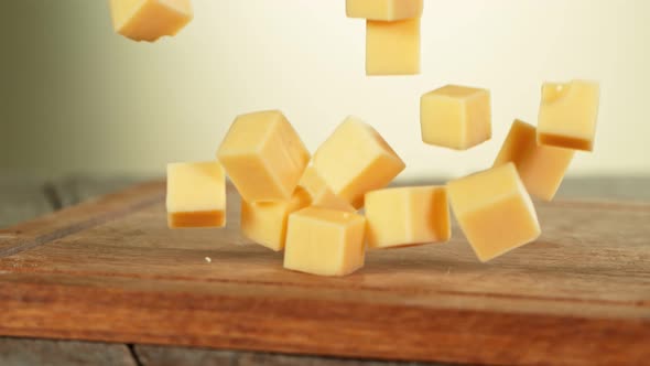 Super Slow Motion Shot of Cheese Chunks Falling on Wooden Board at 1000 Fps.