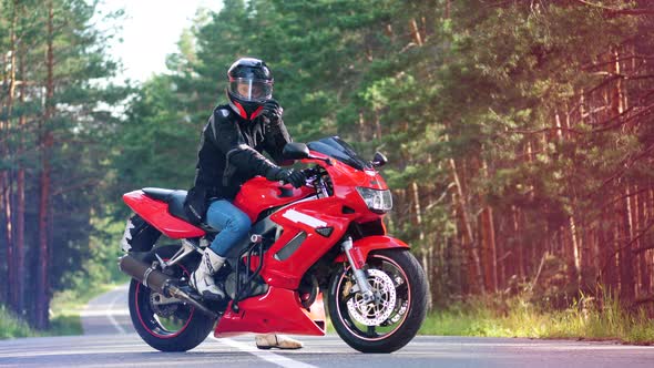 Red Motorbike with the Rider Sitting on It