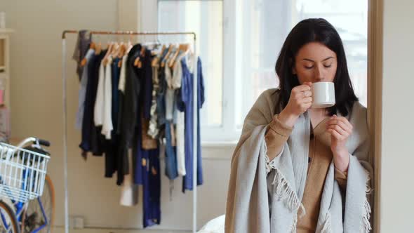 Thoughtful woman having coffee at the door 4k