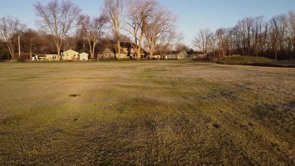 High-Speed Drone Flying Over Golf Course At Sunset To The Golf Pin.